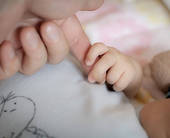 Manina di neonato che tiene il dito della mamma