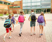 Giovani scolari che entrano a scuola (Foto Dolgachov@123RF.com)