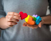 Cuoricini sagomati colorati nelle mani di una donna