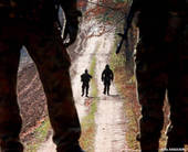 Soldati armati che pattugliano una strada sterrata di campagna