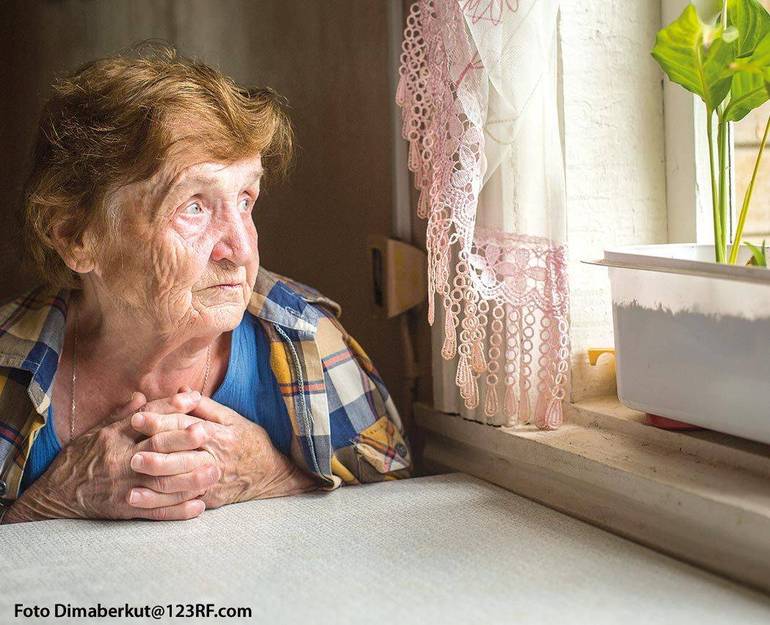 Persona anziana affacciata alla finestra con sguardo preoccupato (Foto Dimaberkut@123RF.com)