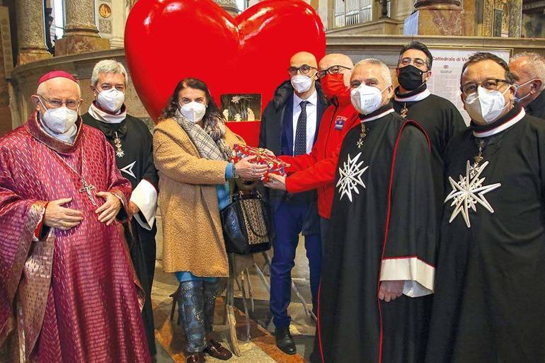 Foto con la consegna delle "scatole di Natale" ai rappresentanti del Cerris dopo la celebrazione presieduta dal mons. Zenti