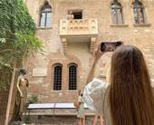 Turista in posa per le foto ricordo presso il balcone di Giulietta a Verona