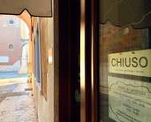 Vetrina del centro storico di Verona con il cartello "Chiuso"