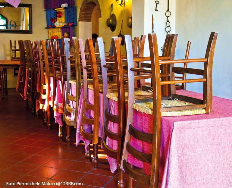Sala ristorante con le sedie capovolte sopra i tavoli (Foto Piermichele Malucci@123RF.com)