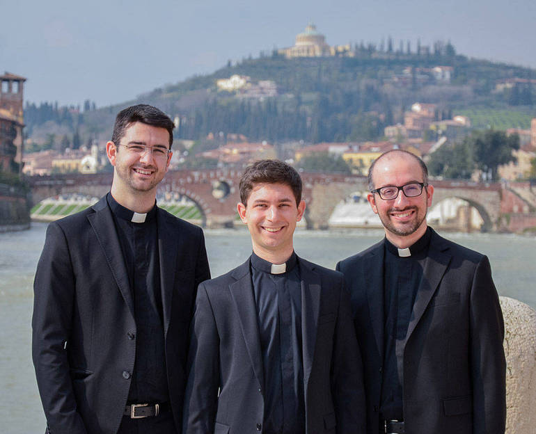 i tre nuovi sacerdoti e sullo sfondo l'Adige e il santuario di Lourdes a Verona