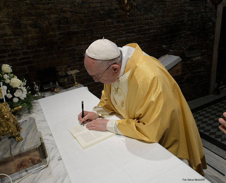 Immagine di papa Francesco che firma la Lettera ai giovani