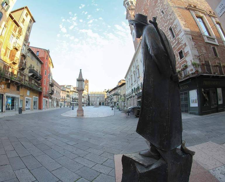 Immagine panoramica di Piazza Erbe deserta sotto lo sguardo della statua di Berto Barbarani