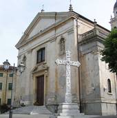 La facciata della chiesa parrocchiale di Colognola con in primo piano la croce in pietra scolpita