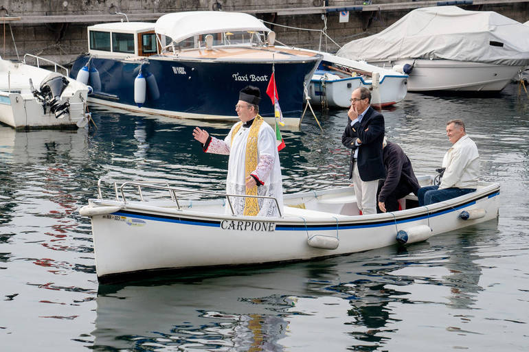 Don Malfer, il parroco arrivato dal lago in barca