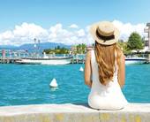 Turista solitaria seduta in riva al lago - Foto Sergio Monti @123RF.com